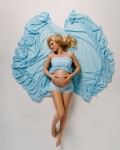 tehotna mamicka leziaca na zemi v dlhych modrych satach