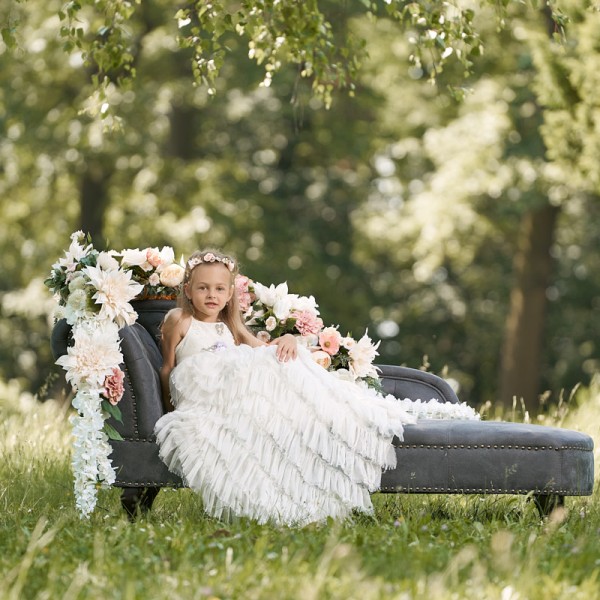 fotka dievcatka v bielych dlhych satach kvetinovej celenke na pohovke s kvetmi